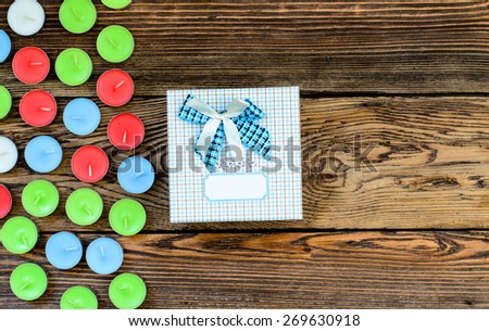 Gift box with many candles on wooden table