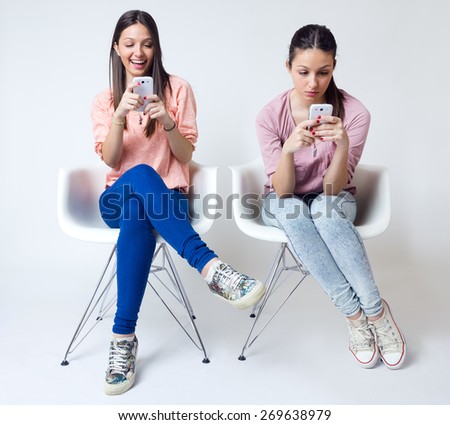 Portrait of beautiful young woman using her mobile phone at home.