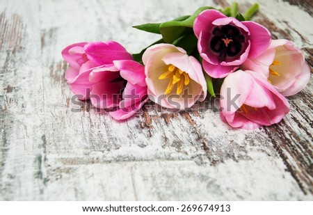 Border with pink tulips on a wooden background