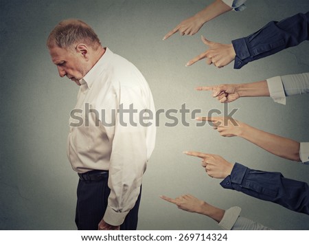 Concept of accusation guilty businessman person. Side profile upset old man looking down many fingers pointing at him isolated grey office wall background. Human face expression emotion feeling  Royalty-Free Stock Photo #269714324