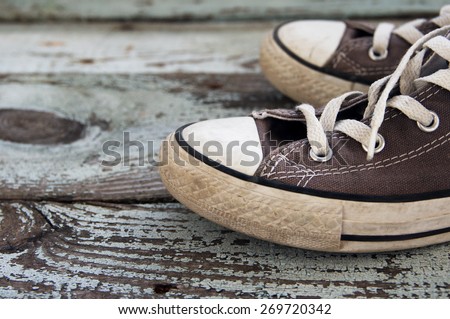 Children's sneakers on an old wooden surface. Sports worn shoes