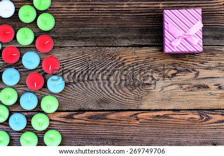 Gift box with candles on wooden background
