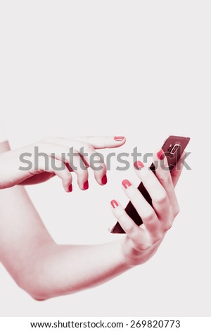 Woman is holding mobile smartphone in her hands on isolated white background, marsala red tuned image