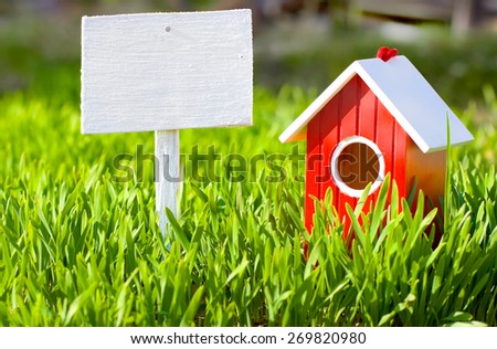 Red house and signboard on grass
