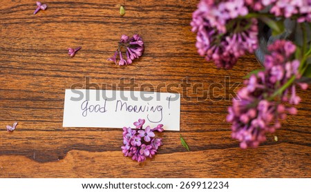 Lilac on the wooden background with good morning note