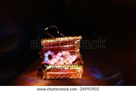Toy trunk with paste pearl. izobrazhayuschiym valuables. A tab is visible which he is suspended for.