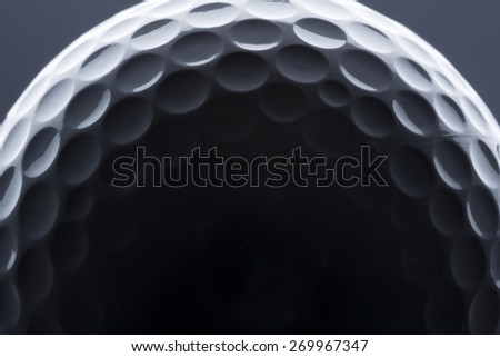 Macro shot of golf ball with dark empty space for text.