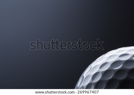 Close up of stylish golf ball isolated on dark blue background, copy space for text.