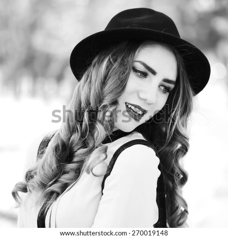 Vintage outdoor lifestyle portrait of pretty funny hipster woman. Modern urban girl having fun. Beautiful young girl in a hat. Black and white portrait, square format with a retro instagram filters.