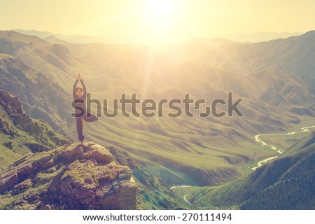 Woman doing yoga in the mountains Royalty-Free Stock Photo #270111494