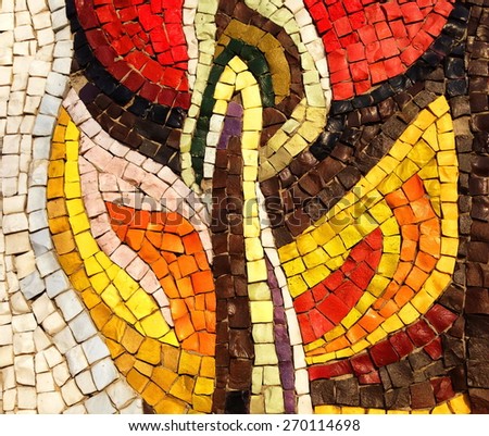 Colorful old stone mosaic on the wall, bright tiles, floral theme