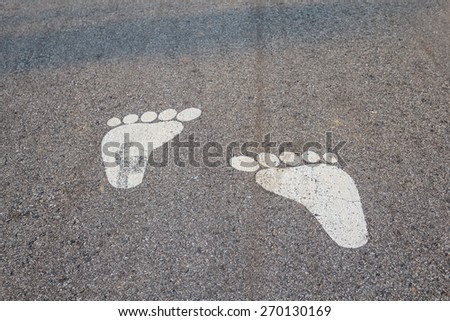 The symbol foot on the street.symbol of foot walk lane on road