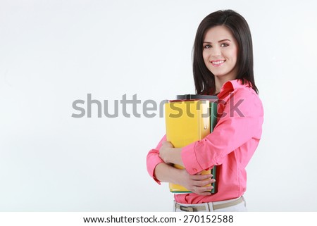 Brunette young woman with colorful folders isolated on white