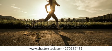 Fit woman running fast, training in bright sunshine Royalty-Free Stock Photo #270187451