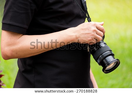 the man hold his camera by right hand