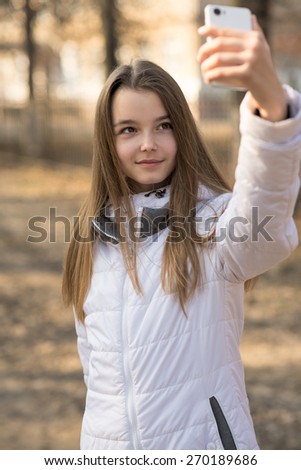 Beautiful girl takes a picture of the self, smiling, spring or fall