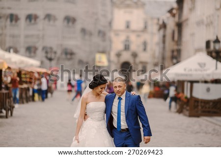 Wedding couple walking in Lviv architecture