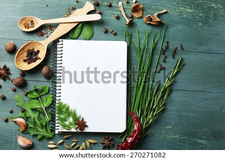 Open recipe book with fresh herbs and spices on wooden background Royalty-Free Stock Photo #270271082