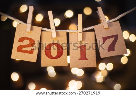 The word 2017 spelled out on clothespin clipped cards in front of glowing lights. Royalty-Free Stock Photo #270271919