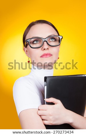 portrait of a woman with glasses on a yellow background. Woman with documents looking up