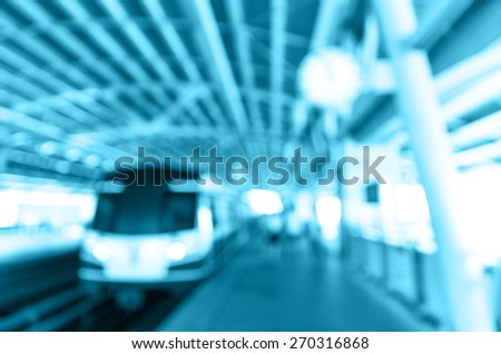Abstract blurred photo of sky train station with people background, blue color tone