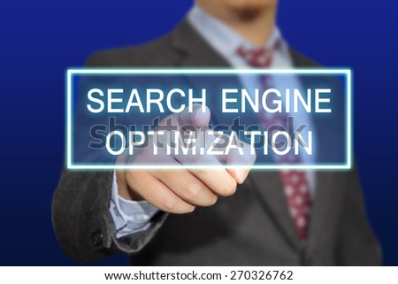 Business concept image of a businessman clicking Search Engine Optimization button on virtual screen over blue background