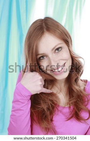 Young woman makes a phoning sign with her hand smiling