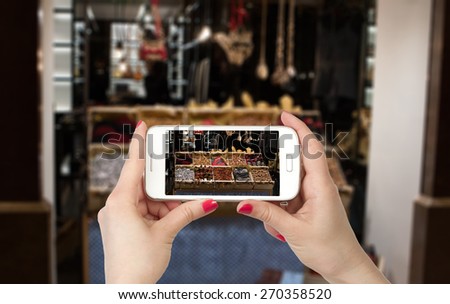 Woman hands photo online with a smart phone. Travel photo storefront.