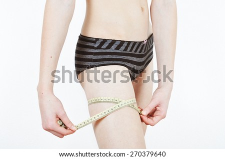 Girl measuring her thigs on a white background
