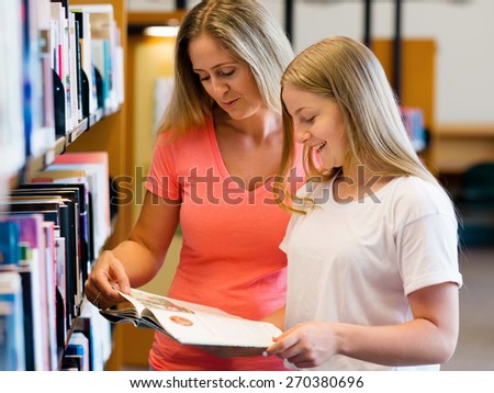 Girl and her mother in library choosing books