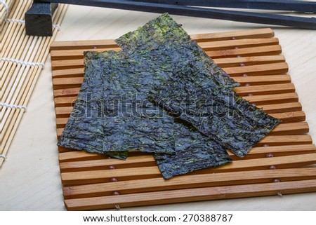 Nori sheets with sticks on the wood background