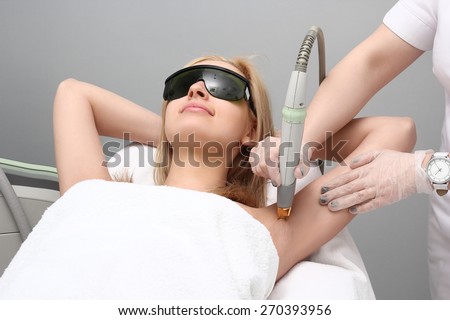Blonde woman having underarm Laser hair removal epilation. Laser treatment in cosmetic salon Royalty-Free Stock Photo #270393956