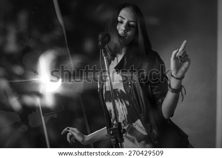 girl singing into a microphone in a studio