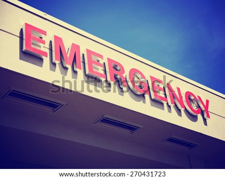 the front entrance sign to an emergency room department in a city hospital toned with a retro vintage instagram filter effect app or action 