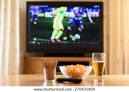 television, TV watching (football, soccer match) with snacks lying on table - stock photo