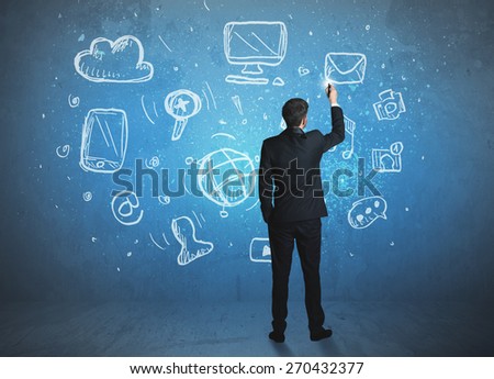  Businessman drawing a media icons on a wall