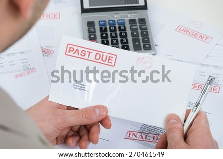 Close-up Of Businessperson Hand Holding Past Due Envelope Royalty-Free Stock Photo #270461549
