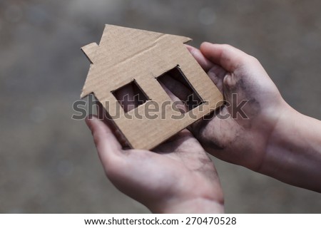 homeless boy holding a cardboard house, dirty hand Royalty-Free Stock Photo #270470528