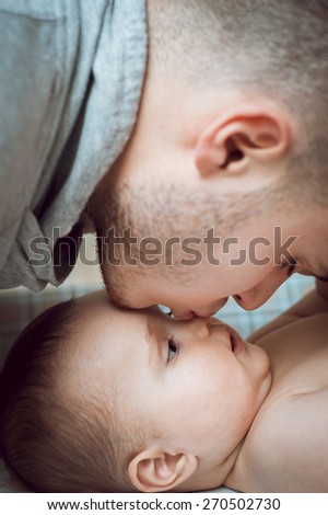 young father dad daughter gently kisses the baby in the nose