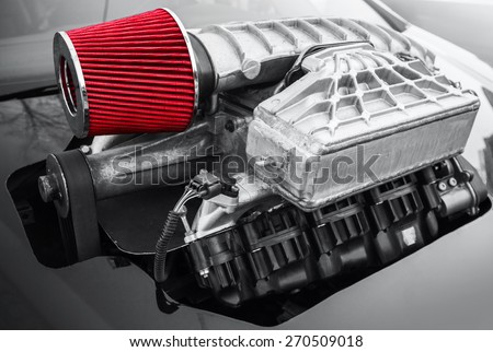 Outer supercharger, air compressor that increases the pressure or density of air supplied to an internal combustion car engine mounted on black hood, closeup photo with selective focus and shallow DOF Royalty-Free Stock Photo #270509018