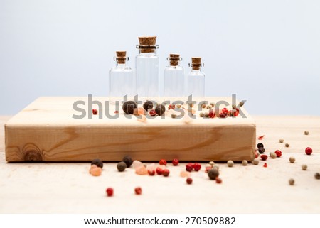 Spices and empty, small glass bottles with wooden texture