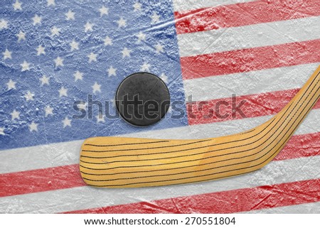 Hockey puck, hockey stick and the image of the American flag on the ice