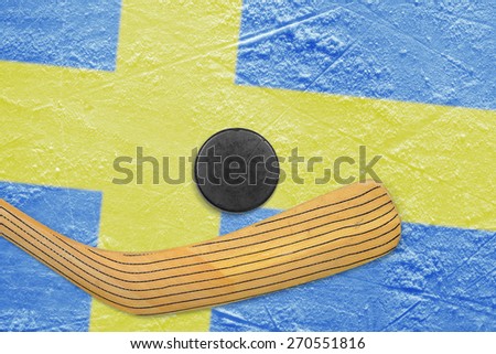 Hockey puck, hockey stick and the image of the Swedish flag on the ice