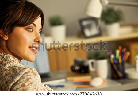 Female photographer sitting on the desk with laptop 