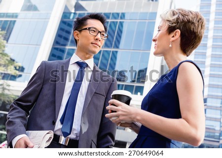 Business people having a talk while walking in a businesss district