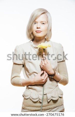 strange slim blonde girl with a yellow flower in her hand