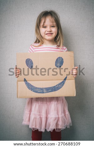little girl holding a cheerful face