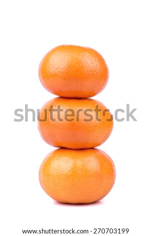 Three mandarin fruit stacked on top of each other on a white background