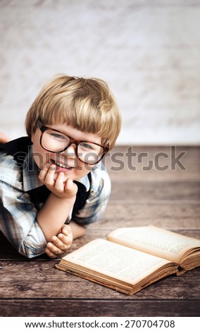 Cheerful smiling little kid reading a book