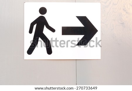 Pedestrian route direction icon and direction on white painted notice board